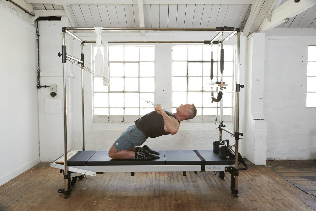 Align Pilates C8-Pro with Full Cadillac, user kneeling and leaning back in a studio