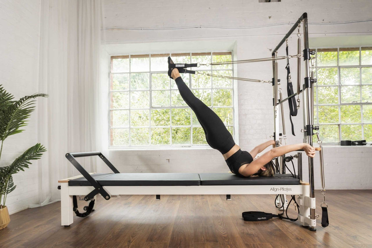 Align Pilates C8-S with Half Cadillac, user lying back with feet in the tower springs