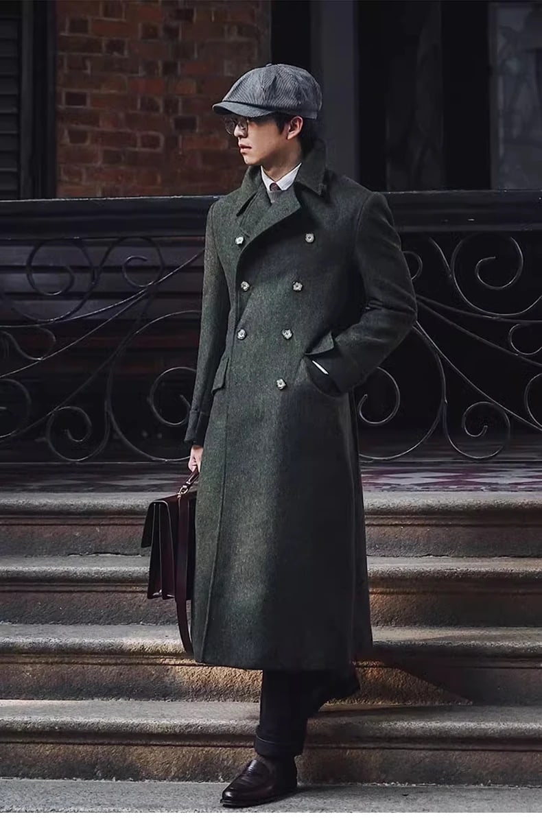 Man in the Hartley double-breasted polo coat in olive on stone steps