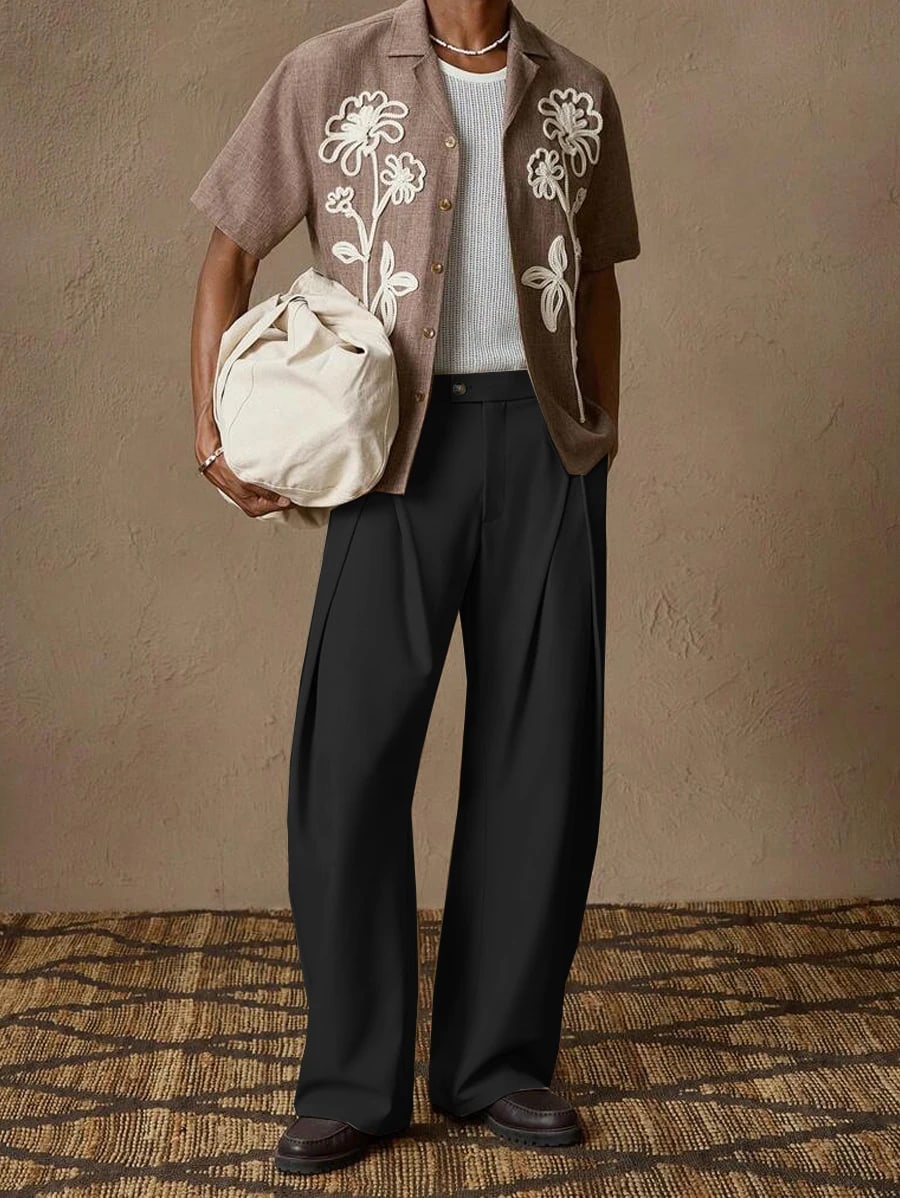 Man wearing the Napoli pleated trousers in black with a short-sleeve shirt