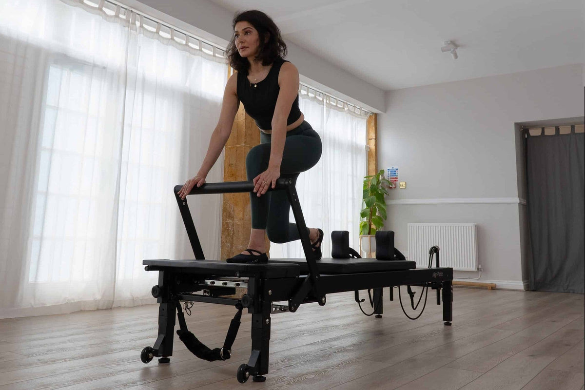 Align Pilates C8-Pro Noir, client stepping onto the carriage in a studio
