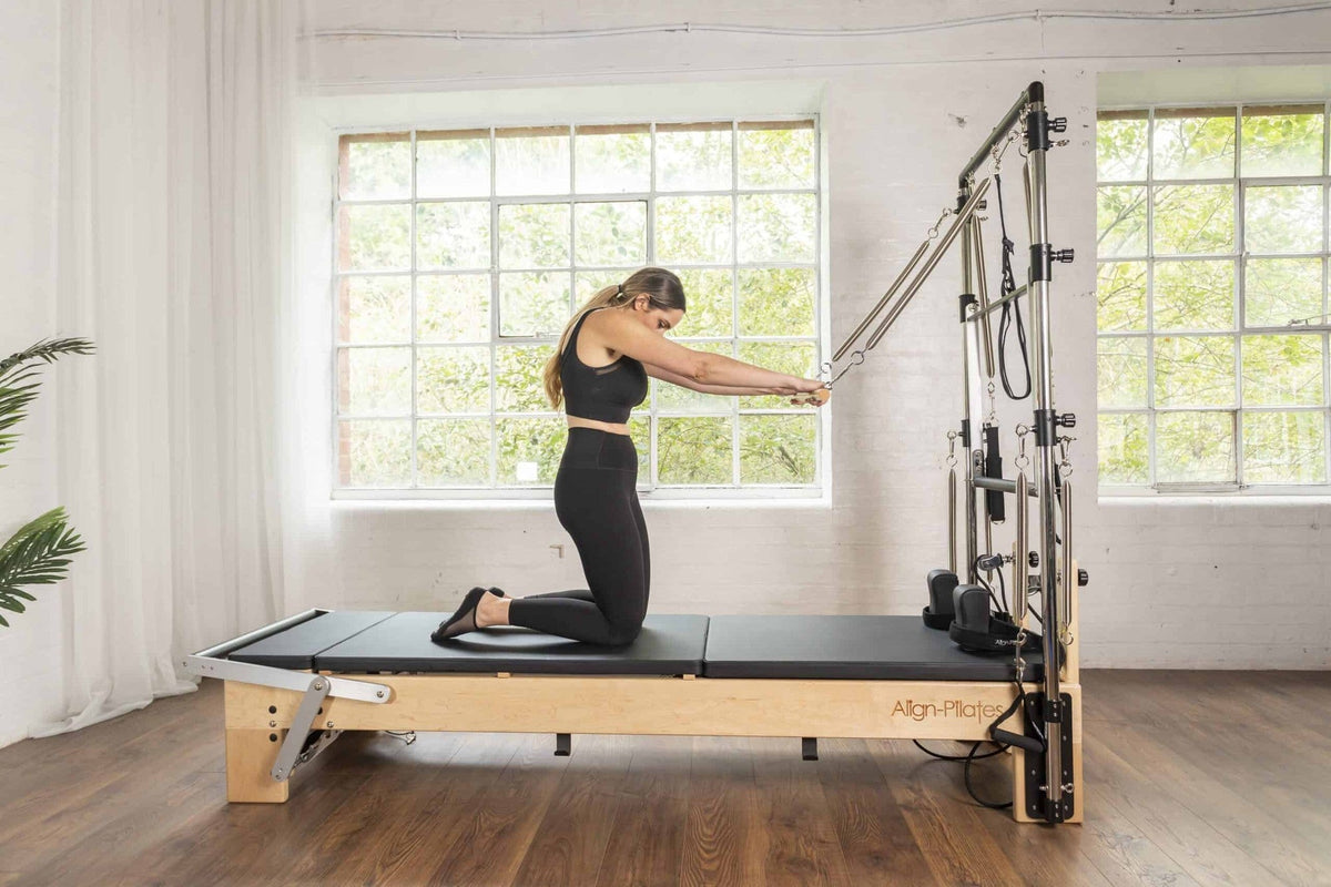 Align Pilates Mat Converter for M Series, client kneeling on the flat bed
